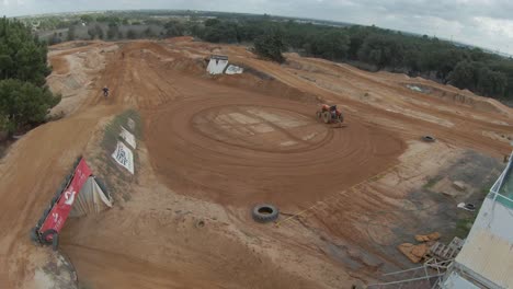 Un-Piloto-De-Motocross-Ejecuta-Un-Gran-E-Impresionante-Salto-Sobre-Una-Pista-De-Tierra-En-Movimiento