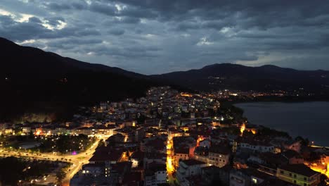 Nächtliches-Kastoria,-Griechenland:-Faszinierende-Stadtlichter-Und-Seereflexionen-–-4K-Luftgenuss