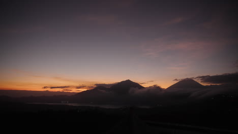 Birds-fly-across-cloudy-Bali-Batur-mount-sunrise-from-far-wide