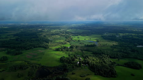Aerial-View-Over-Latvian-Countryside-Landscape-with-Green-Scenery-and-Low-Clouds