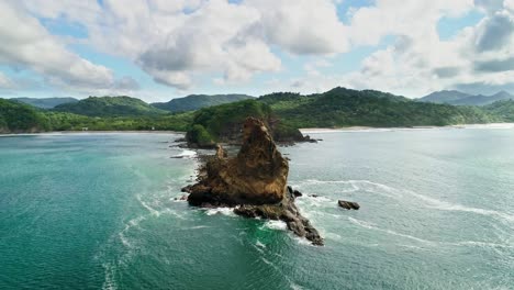 Impressive-rocky-cliff-island,-picturesque-coast-of-Nicaragua,-cinematic-drone