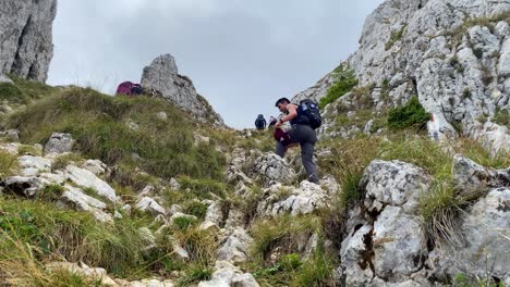 Foto-De-ángulo-Bajo-De-Turistas-Escalando-Con-Confianza-A-Lo-Largo-De-La-Ladera-Rocosa-De-La-Montaña-En-Brasov,-Rumania-En-Un-Día-Nublado