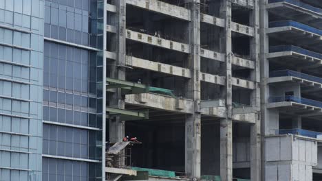 Gebäude-Im-Bau-In-Jakarta-Mit-Arbeitern,-Die-Das-Gelände-Von-Verschiedenen-Etagen-Aus-In-Indonesien-überwachen