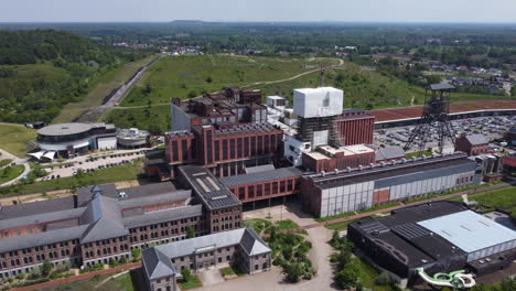 Aerial-flying-towards-buildings-in-beMINE-Beringen-on-sunny-day,-Belgium