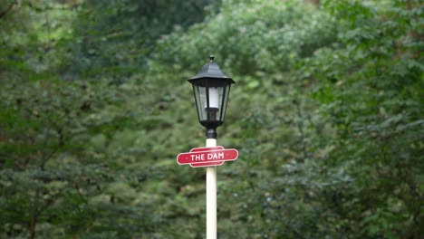 Close-up-of-cute-vintage-lamp-with-red-'The-Dam'-sign,-in-4K
