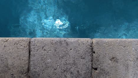Close-shot-of-natural-stones-going-around-the-swimming-pool