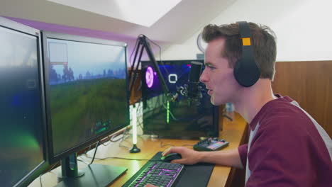 Man-Gaming-At-Home-Sitting-At-Desk-Wearing-Headphones-For-Live-Stream