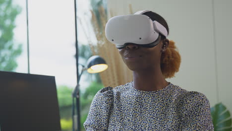 Nahaufnahme-Einer-Frau,-Die-Im-Heimbüro-Am-Schreibtisch-Sitzt-Und-Ein-VR-Headset-Mit-AR-Technologie-Trägt