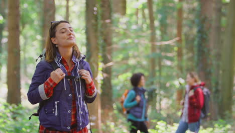 Woman-Closing-Eyes-Enjoying-Peace-As-Group-Of-Female-Friends-On-Holiday-Hike-Through-Woods-Together