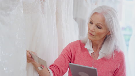 Ältere-Inhaberin-Eines-Brautmodengeschäfts-Mit-Digitalem-Tablet