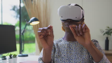 Woman-Working-From-Home-Office-At-Desk-Wearing-VR-Headset-Interacting-With-AR-Technology