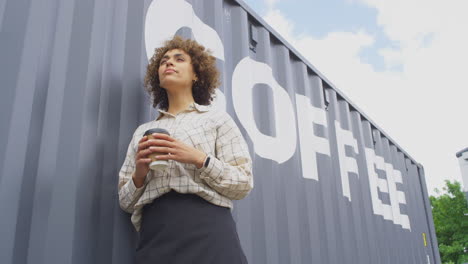 Portrait-Of-Female-Owner-Of-Coffee-Shop-Or-Distribution-Business-Standing-By-Shipping-Container