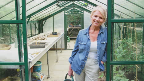 Portrait-Of-Mature-Woman-Gardening-In-Greenhouse-At-Home