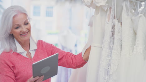 Ältere-Inhaberin-Eines-Brautmodengeschäfts-Mit-Digitalem-Tablet