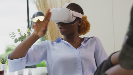 Frau,-Die-Im-Heimbüro-Am-Schreibtisch-Arbeitet-Und-Ein-VR-Headset-Trägt,-Veranstaltet-Ein-Virtuelles-Online-Meeting