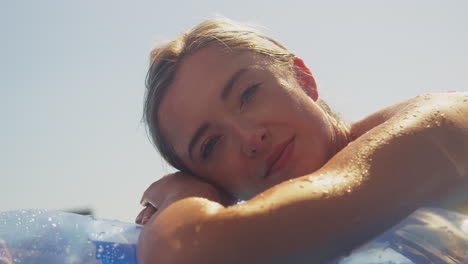 Frau-Im-Sommerurlaub-Entspannt-Sich-Auf-Einer-Aufblasbaren-Luftmatratze,-Die-Im-Schwimmbad-Schwimmt