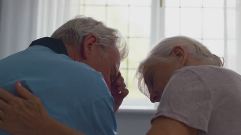 Nahaufnahme-Eines-Besorgten-Rentnerpaares,-Das-Zu-Hause-Im-Bett-Sitzt-Und-Miteinander-Redet