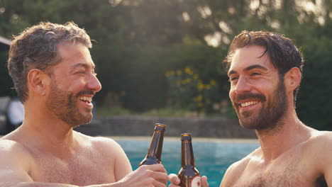 Pareja-Masculina-Del-Mismo-Sexo-De-Vacaciones-En-La-Piscina-Bebiendo-Cerveza-Juntos