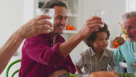 Mehrgenerationenfamilie-Feiert-Thanksgiving-Zu-Hause,-Isst-Essen-Und-Jubelt-Mit-Wasser