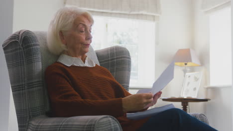 Besorgte-ältere-Frau-Schaut-Zu-Hause-Auf-Die-Energierechnung-Während-Der-Lebenshaltungskosten-Energiekrise