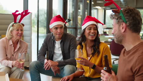 Staff-Celebrating-At-Christmas-Party-Dressing-Up-Enjoying-Drinks-In-Office