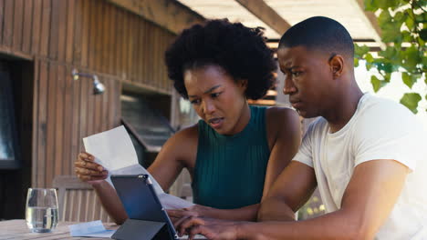 Worried-Couple-Using-Laptop-At-Home-To-Check-Domestic-Finances