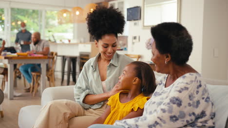 Multi-Generation-Female-Family-Hanging-Out-On-Sofa-At-Home-Talking-Together