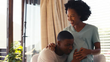 Couple-With-Pregnant-Woman-In-Bedroom-At-Home-With-Man-Listening-To-Baby's-Heartbeat