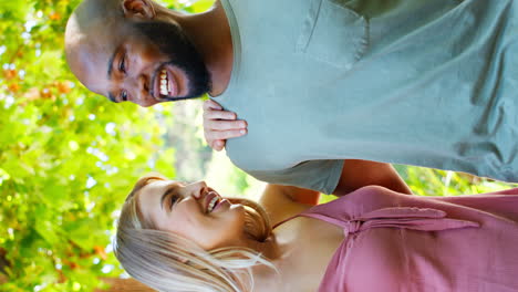 Vertical-Video-Of-Loving-Multi-Racial-Couple-Standing-Outdoors-In-Garden-Park-Or-Countryside