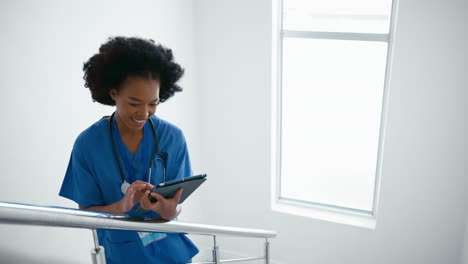 Ärztin-Oder-Krankenschwester-Mit-Digitalem-Tablet,-Die-Patientennotizen-Auf-Treppen-Im-Krankenhaus-überprüft