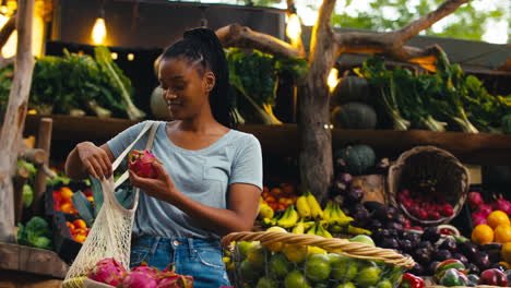 Female-Customer-At-Market-Stall-Choosing-Fresh-Fruit-And-Vegetables