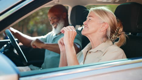 Senior-Couple-In-Car-Singing-Along-With-Radio-On-Day-Trip-Out-Together