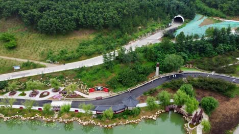 Aerial-panning-shot-of-the-beautiful-Huaxiacheng-park-in-Weihai-city-in-china-with-view-of-lakes-and-buildings-in-chinese-architecture-in-the-middle-of-a-beautiful-landscape