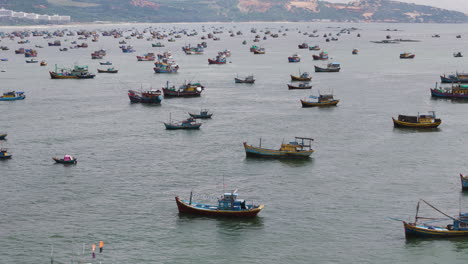Traditional-fishing-boats-anchored-in-Mui-Ne-harbour,-Vietnam,-aerial-view