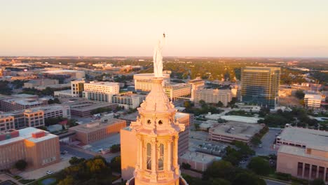 Downtown-Austin,-Texas-State-Capital-Building,-Aerial-Drone-Shot-Flying-Around-Goddess-of-Liberty-Statue-on-Top-with-Views-of-The-University-of-Texas-at-Austin-Campus-Skyline-at-Sunset-in-4K
