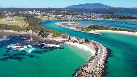 Drone-aerial-rock-wall-channel-beach-inlet-channel-coastline-headland-Narooma-Wagonga-beach-travel-tourism-South-Coast-NSW-Australia-4K