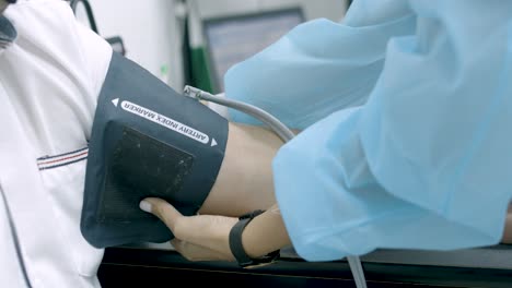 Ärztin-Bereitet-Blutdruckmessgerät-Am-Arm-Eines-Patienten-Im-Krankenhaus-Vor