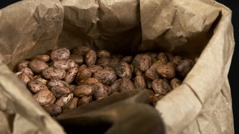 Spotted-dry-Pinto-Beans-in-paper-bag-rotate-in-close-up-macro-view