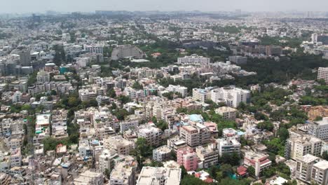 Aerial-cinematic-footage-of-a-city-in-India-shows-buildings-and-trees-paralleling-railroad-tracks-and-a-metro-station-in-the-middle-of-the-city