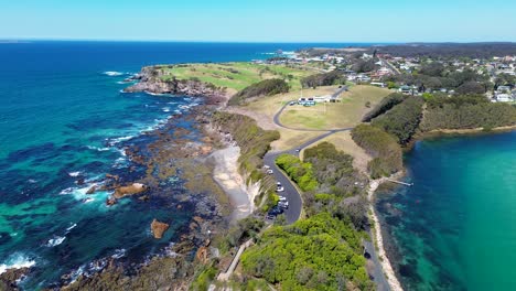 Drone-aerial-landscape-shot-carpark-Wagonga-head-rocky-coastline-beach-town-suburb-Narooma-South-Coast-travel-tourism-NSW-Australia-4K
