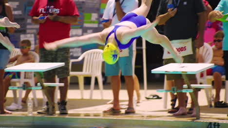 Professional-swimmer-athlete-jumps-into-swimming-pool-water-from-trampoline