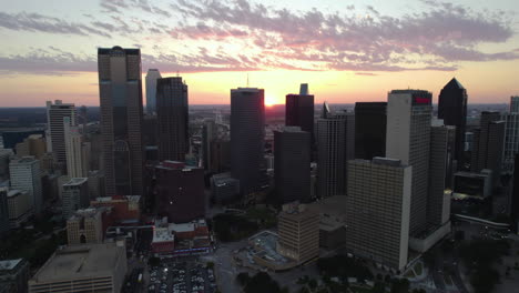 Aerial-view-backwards-away-from-the-City-Center-District-of-Dallas,-sundown-in-USA