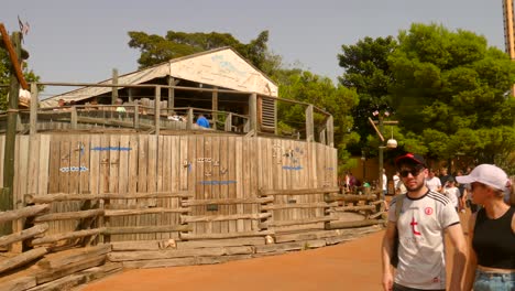 Toma-Panorámica-De-La-Entrada-De-La-Montaña-Rusa-De-Madera-Tomahawk-En-El-Parque-De-Atracciones-Port-Aventura-En-Salou,-España,-En-Un-Día-Soleado