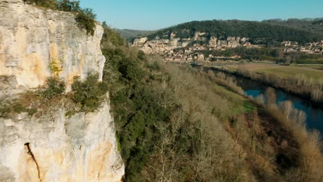 Discover-the-village-of-La-Roque-Gageac-via-the-cliffs,-wide-angle-drone-shot