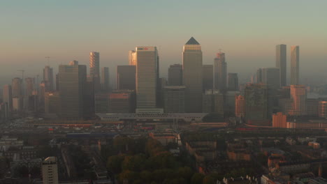 Toma-Aérea-Ascendente-De-Canary-Wharf-Desde-Los-Muelles-De-álamo-Al-Amanecer