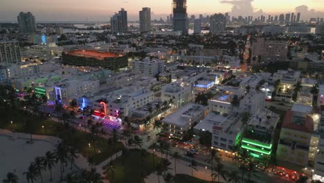 south-Beach-illuminated-at-night-with-cityscape-skyline-restaurant-and-ocean-drive-road
