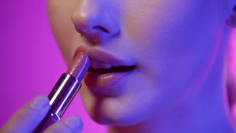 Close-up-shot-of-a-beautiful-young-woman-lips-as-she-presses-her-lips-together-to-spread-her-newly-applied-lipstick-after-getting-ready-for-club-night-evenly-in-slow-motion