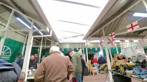 POV-shoppers-looking-around-British-flea-market-at-variety-of-disposable-unwanted-objects-for-a-cheap-bargain