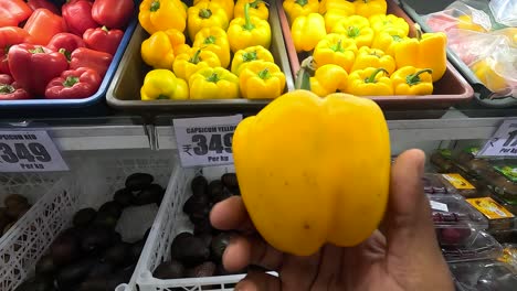 POV-shoot,-woman-buying-fresh-yellow-capsicum-from-vegetables-market-in-super-market