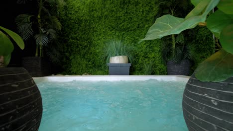 Slow-motion-dolly-shot-of-an-outdoor-hot-tub-bubbling-away-decorated-with-plants